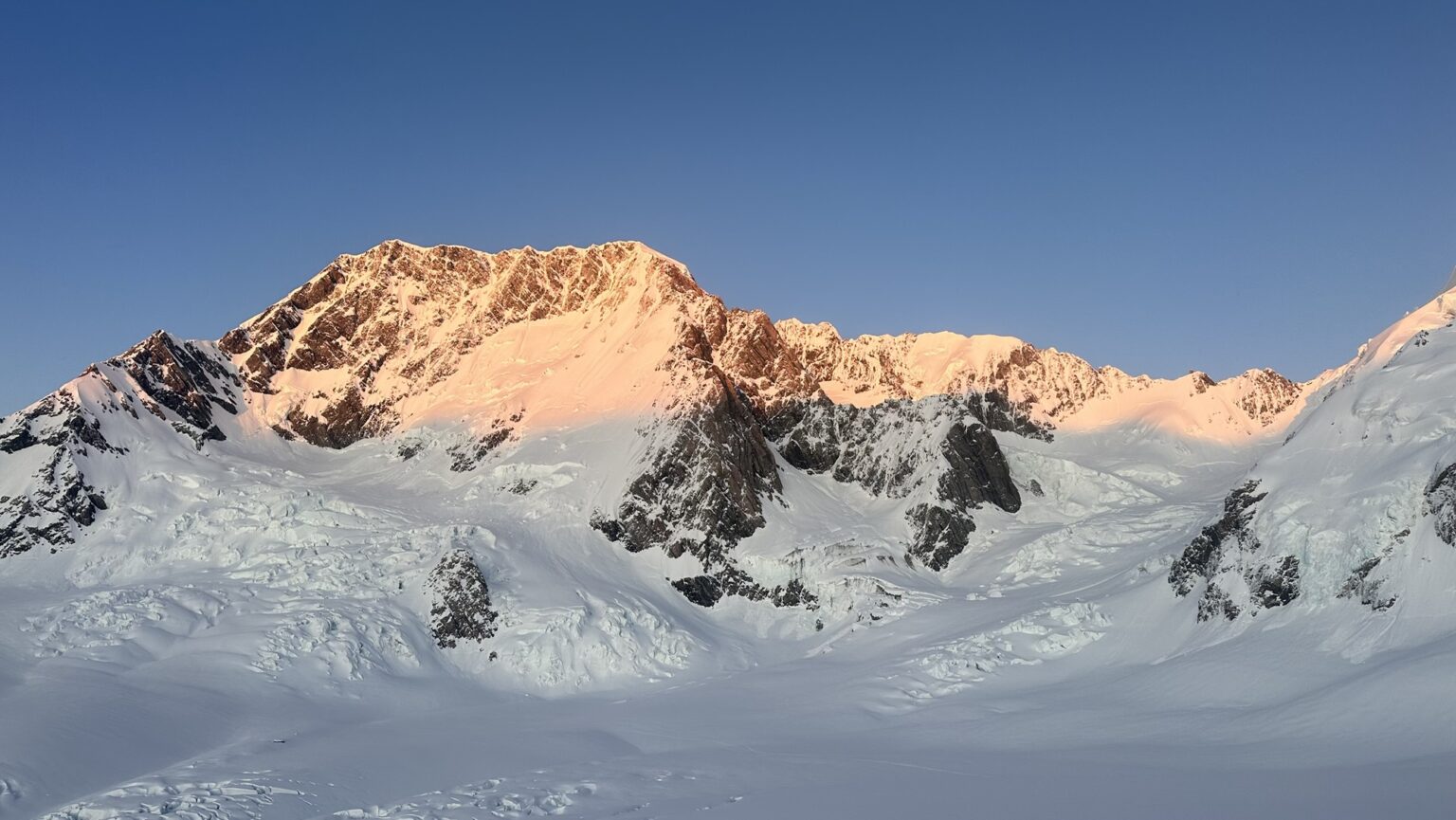 Climb Aoraki / Mt Cook - Early morning light strikes the east face of the mountain